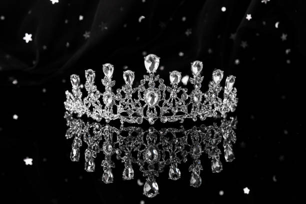 istock Beautiful silver tiara with diamonds on dark mirror surface 1465534013