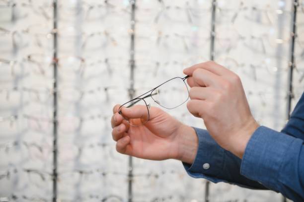 istock Man evaluating quality of glasses in optical shop 1465534577