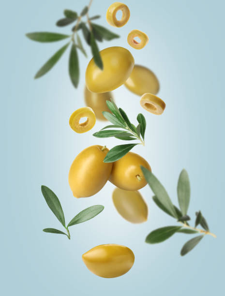 istock Fresh olives and leaves falling on pale light blue background 1465534620
