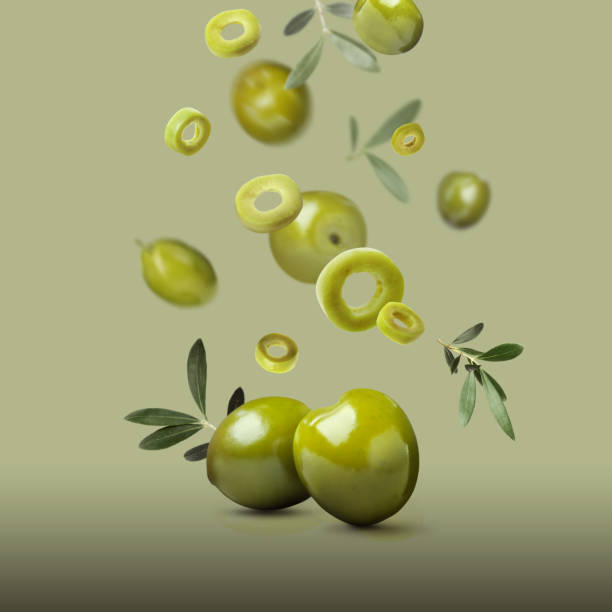 istock Fresh olives and leaves falling on pale olive background 1465534632