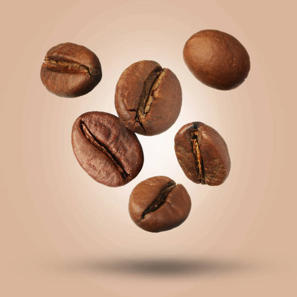 istock Many roasted coffee beans falling on beige background 1465534694