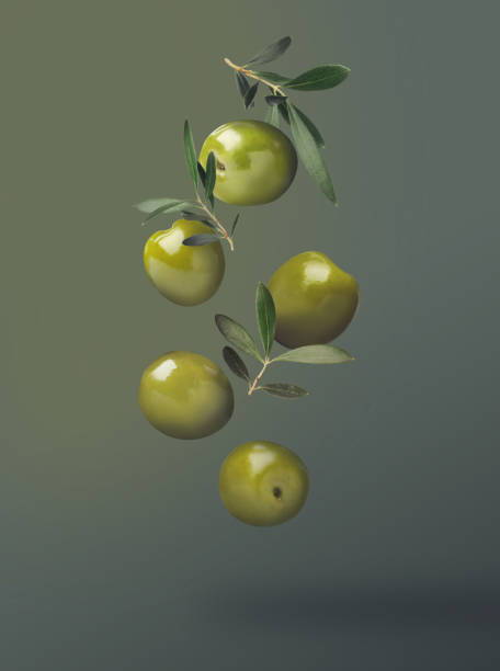 istock Fresh olives and leaves falling on color background 1465534697