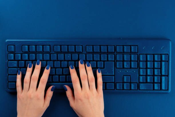 istock Woman hands typing on computer keyboard on classic blue background 1465535309