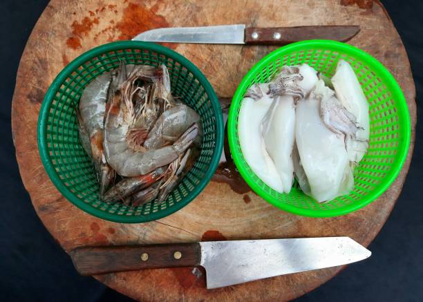 Fresh Squids and Shrimps on cutting board - food preparation.