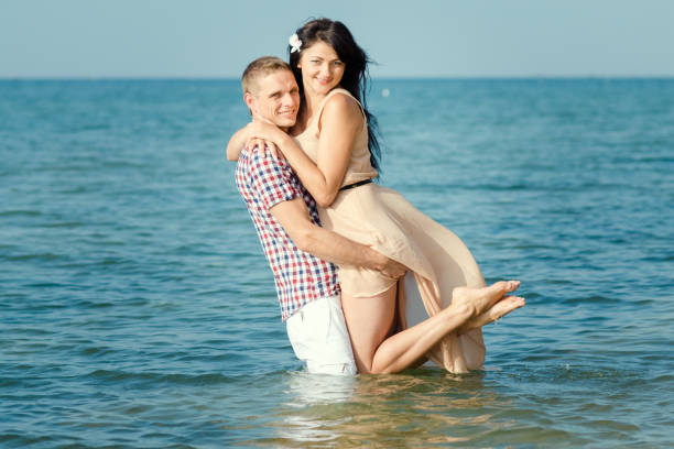 istock a guy and a girl walk along the seashore 1465538794