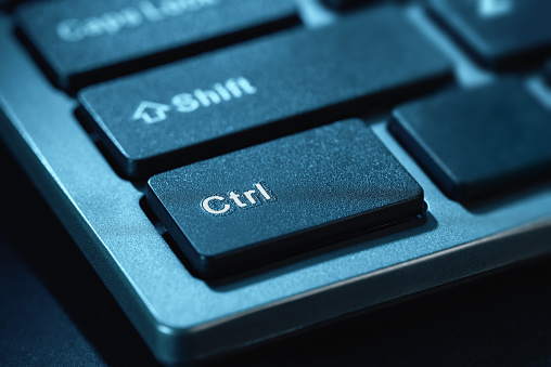 Close-up macro shot of the black keys of a desktop computer keyboard. Selective focus on the Ctrl key. Toned.