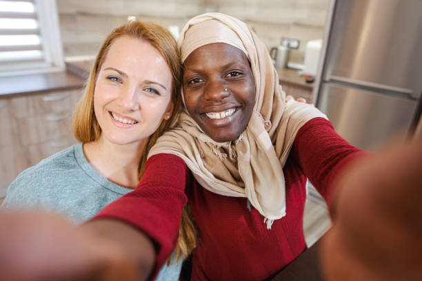 istock Two multiracial female friends taking selfies together 1465540771