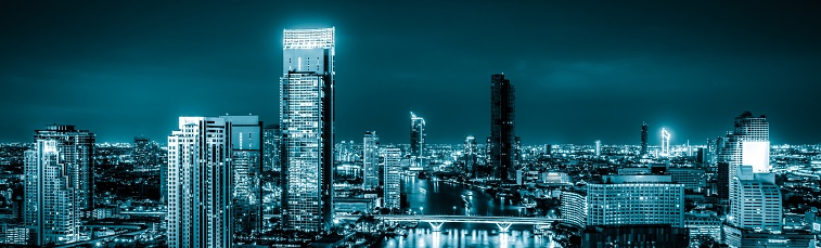 Blue-filtered cityscape and high-rise buildings in metropolis city center . Downtown business district in panoramic view .