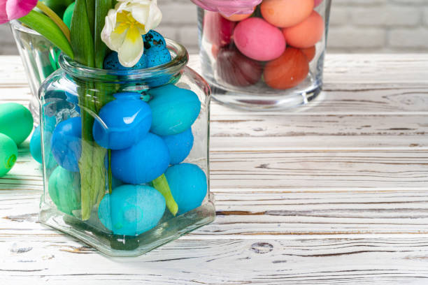 istock Vibrant Easter eggs with flowers in a glass jar close up, cropped image 1465540948