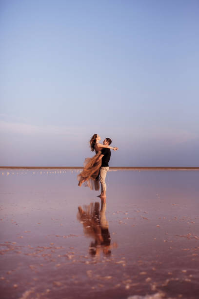 menina e um cara na margem de um lago salgado rosa - pink pants summer two people - fotografias e filmes do acervo