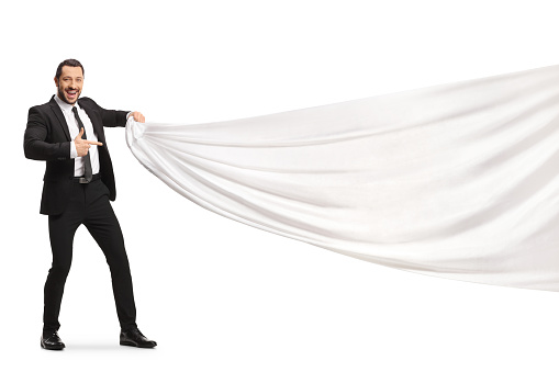Businessman pulling a white piece of cloth and pointing isolated on white background