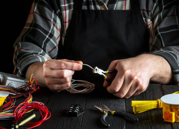 istock Master electrician cuts the wire with diagonal pliers. Working environment on workshop table 1465543425