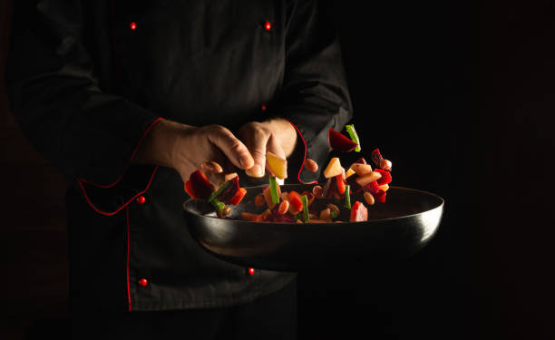 istock Cooking fresh vegetables in a frying pan by a chef for a vegetarian diet. Space for advertising a hotel or restaurant 1465544430