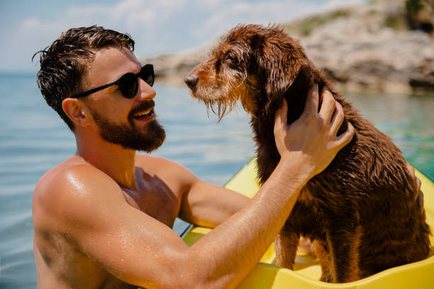 istock Handsome men having fun with his old dog in kayak 1465544547