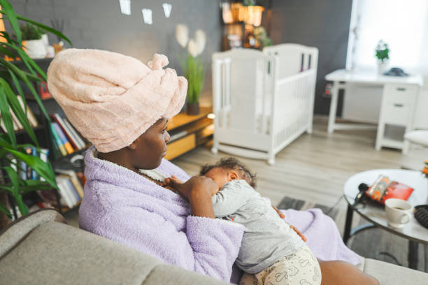 istock Black mother in bathrobe after shower breastfeeding her baby son 1465548430