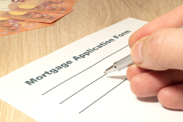 istock Mortgage with a pen, money and hand on the table. 1465549092