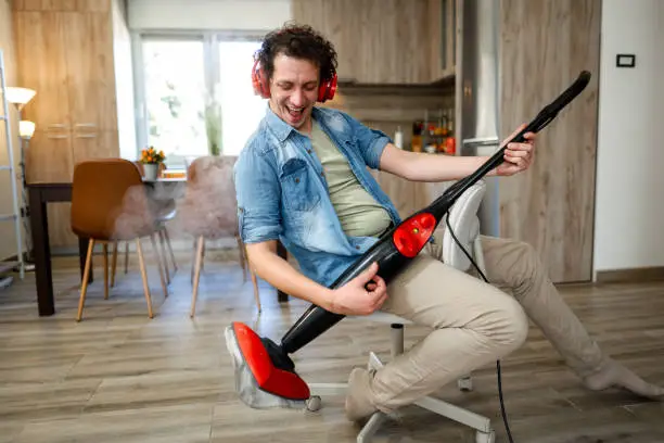 Photo of Men having fun with steam cleaner while listening to music