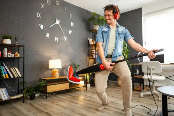 Photo of Men having fun with steam cleaner while listening to music