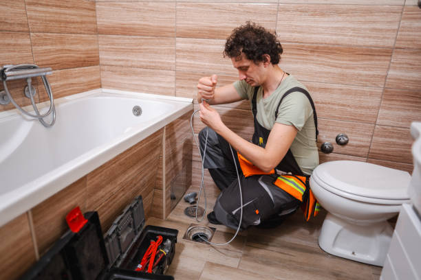 istock Plumber unclogging bathroom sewage by turning steel cable 1465558765