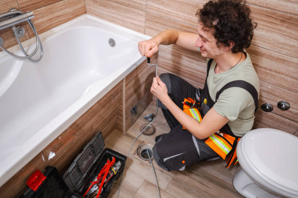 istock Plumber unclogging bathroom sewage by turning steel cable 1465559062