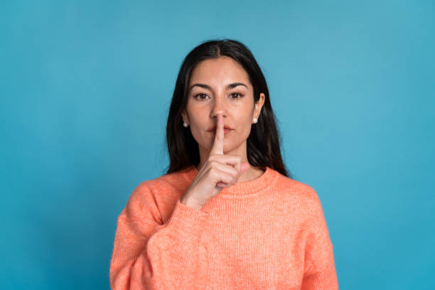istock Young woman showing silence gesture in studio 1465559291