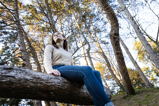 Relaxed woman breathing fresh air in a green forest.
