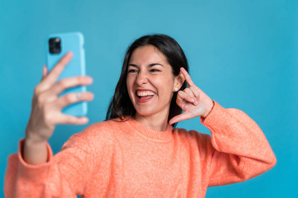 istock Smiling woman taking selfie on smartphone 1465559564