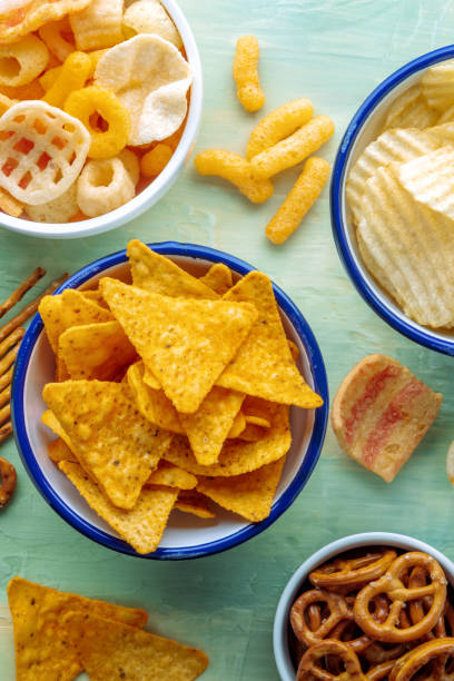 istock Tortilla chips, salt ptetzels and other salty snacks, overhead flat lay shot 1465560224