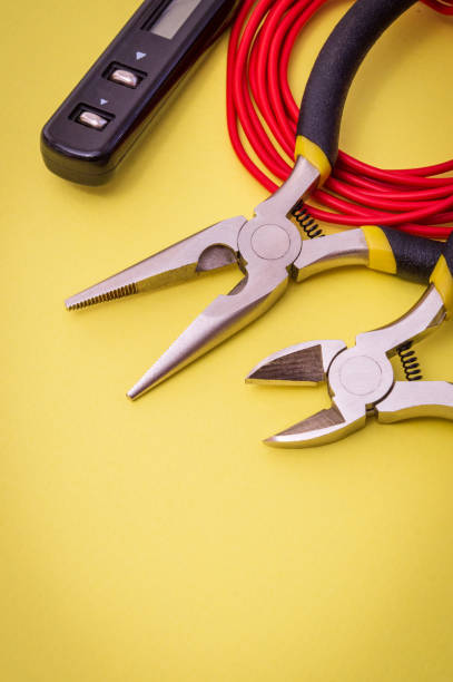 istock Electrician tools and red wire on yellow background for repairing energized systems or communications 1465560932