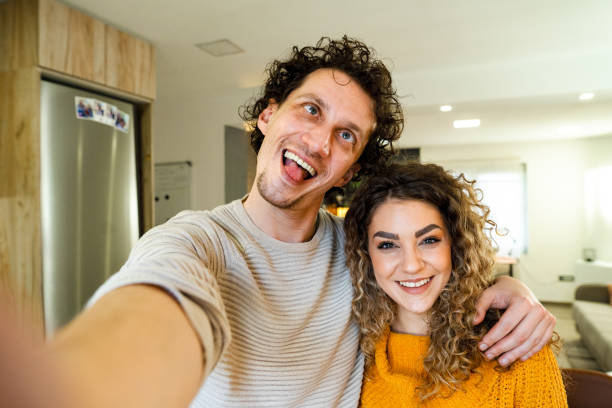 istock Young couple making goofy selfies in their apartment 1465561416