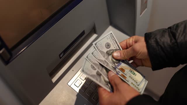 Man receives dollar money from ATM closeup