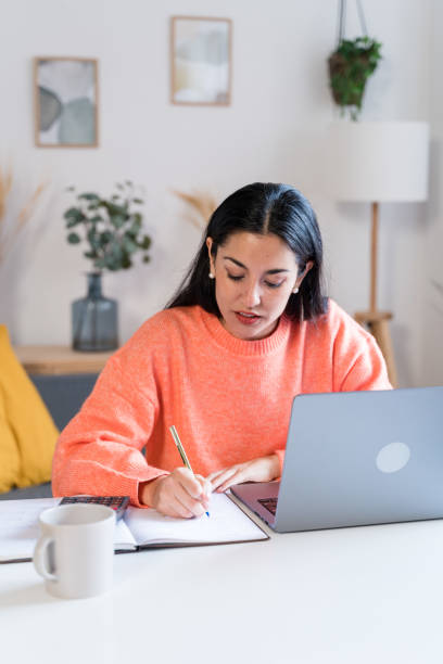 istock Focused woman working on laptop and drinking coffee 1465567683