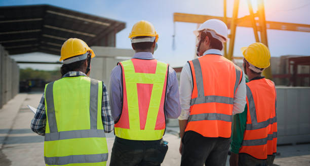 istock Back view of Asian civil engineer or Architect, inspector with contractor, foreman or worker wear safety helmet. Colleagues discussing, meeting about construction building project on site. 1465568271