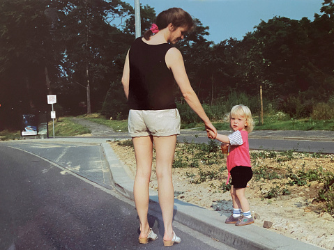 Toddler girl walking with her mother