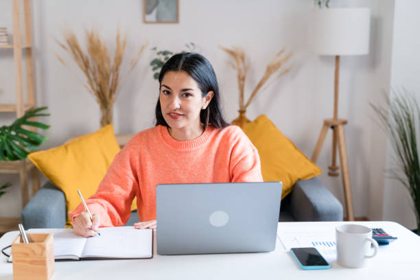 istock woman writing in notepad working from home 1465569034