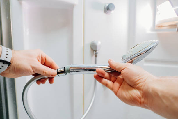 istock men's hands screw the shower head onto a new hose. 1465572436