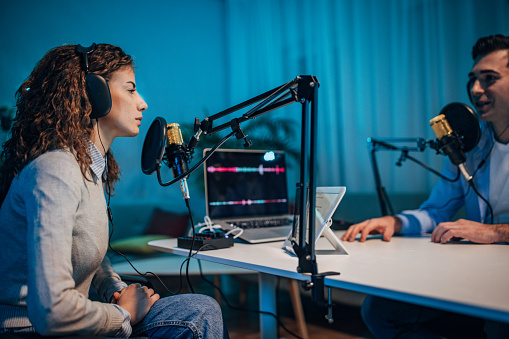 People in the podcast studio talking and recording