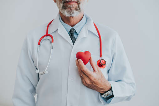 Portrait of a doctor holding a heart in his hands