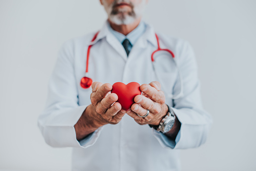 Retrato de un médico sosteniendo un corazón en sus manos photo