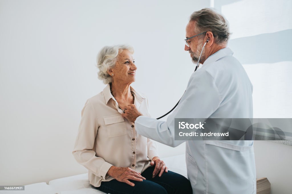 Doctor listening to senior woman patient heartbeat Doctor Stock Photo
