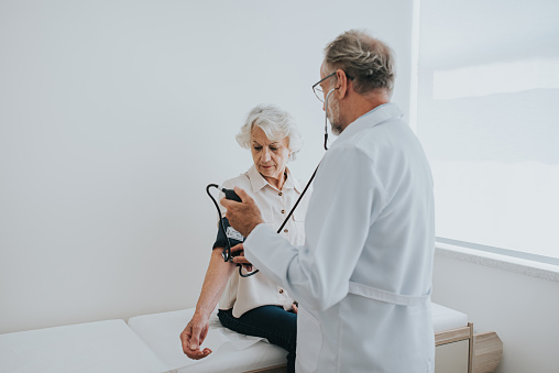 Senior patient measuring blood pressure in arm