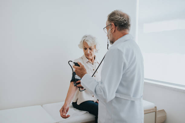 Senior patient measuring blood pressure in arm stock photo
