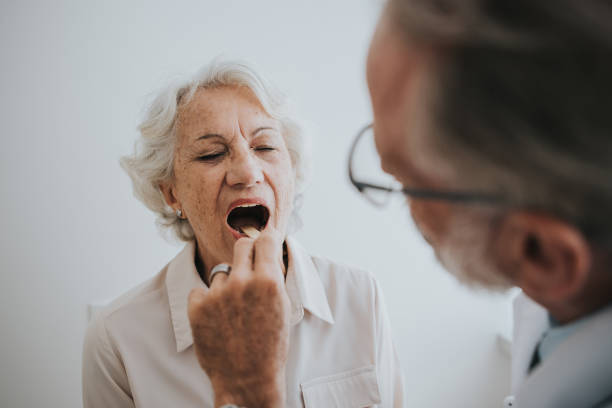 istock Senior patient with tongue stick sore throat 1465572979