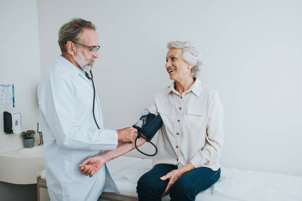 senior patient measuring blood pressure in arm - outpatient imagens e fotografias de stock