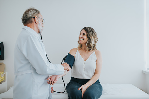 Doctor measuring patient's body pressure in medical office