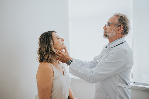 Doctor evaluating patient's sore throat