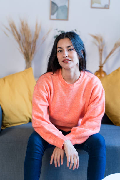 istock Smiling woman sitting on sofa 1465573558