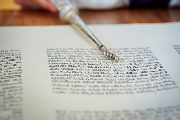istock Close Up of Yad Pointing at Hebrew Letters in Torah Scroll 1465575562
