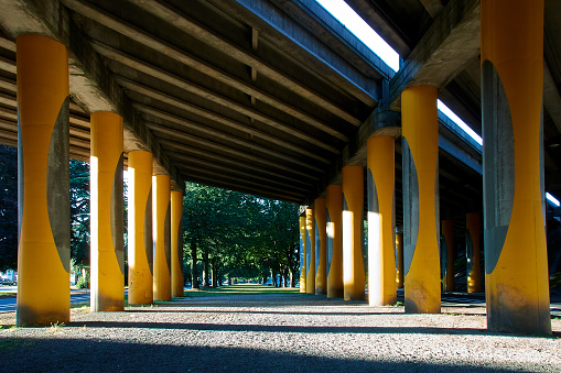 Highway Underpass with Yellow Pillars and Bright Sunlight