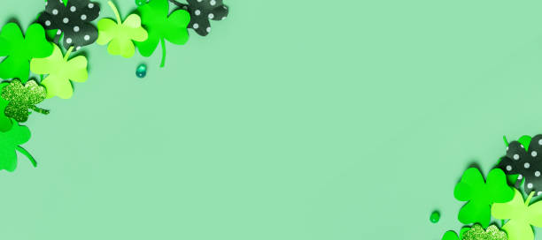 istock St. Patrick's Day flat lay banner. Paper clover leaves on colored background with copy space 1465576409